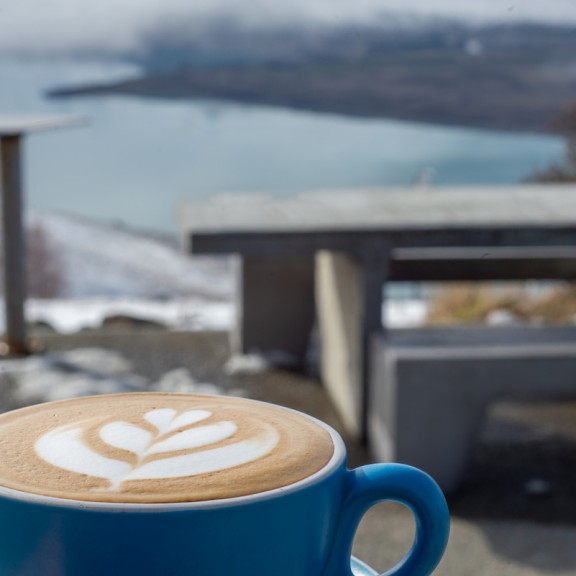 Flat white served outside with a view over lake Takapo