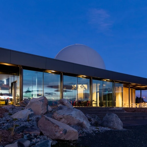Exterior of Dark Sky Project Base Building from Lake in evening