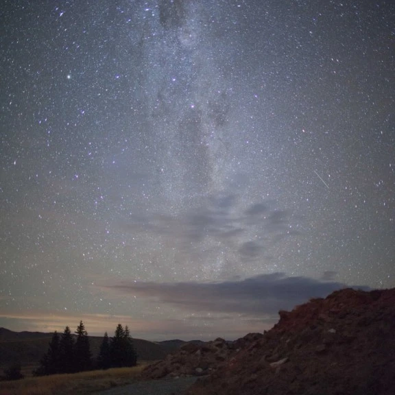 View of stoney road on edge of crater looking to milky way in night sky