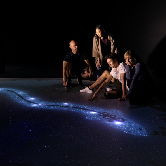 Family group looking down at illustration on ground