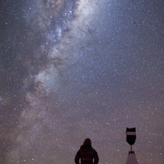 Silhouette of a person looking up to the night sky and milky way